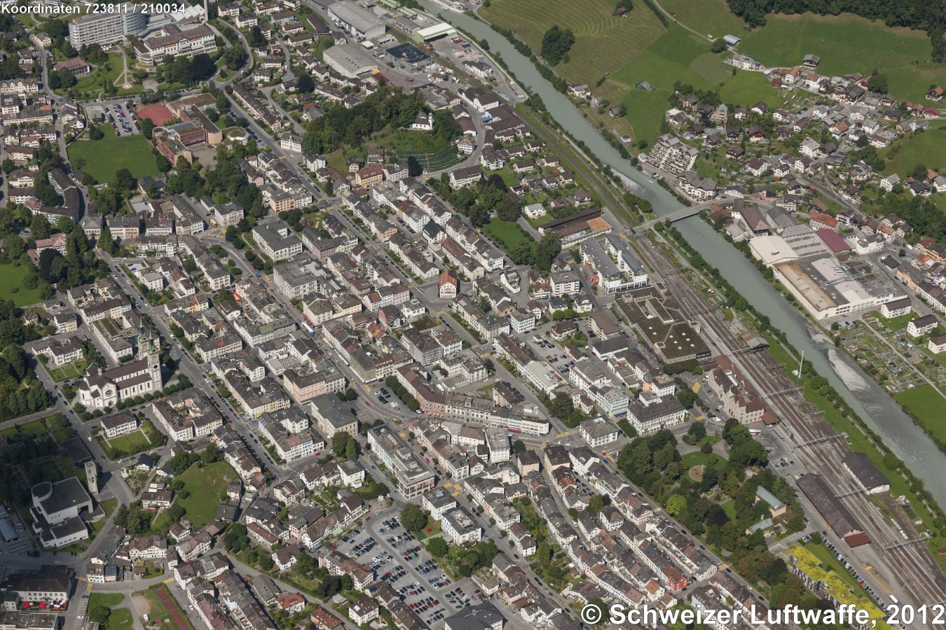 Glarus (Position:2'723'810.87, 1'211'184.63), Grünfläche links der Linth (rechts unten): 'Volksgarten'. Links im Bild: evangel.-reform. Stadtkirche. Oben im Bild: 'Burghügel Bürgli'. Die Burgstrasse durchquert das Bild von unten links nach oben rechts: hier (vor der Kurve): Kantonsschule, ganz hinten links: Kantonsspital.